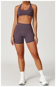 Modella che indossa un set da yoga viola con canotta e pantaloncini da ciclista a vita alta