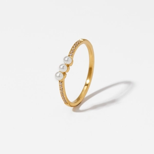 Elegant gold stainless steel ring with three pearls and small diamonds on white background