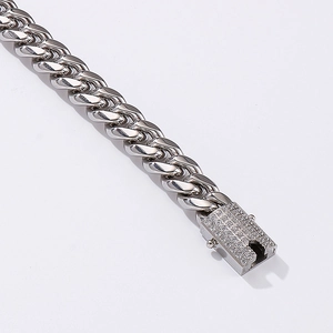 Polished silver metal Cuban link chain with a sparkling diamond-encrusted buckle clasp