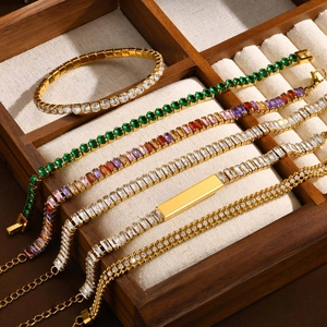 Elegant stainless steel gold and silver bracelets with green zircon in a wooden jewelry box