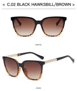 Detail view of square black tortoiseshell sunglasses with elegant pearl chain temples