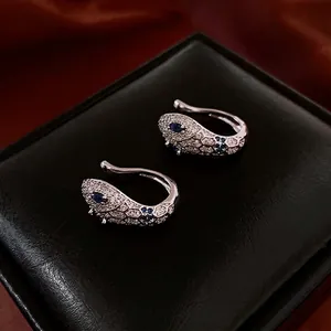 Silver snake ear cuffs with micro-set white and blue zircons on a black leather display