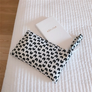 Close-up of quilted white heart pattern mini pouch showing fabric texture and inner capacity