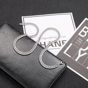 Detailed view of silver stainless steel curb chain necklace on a black background