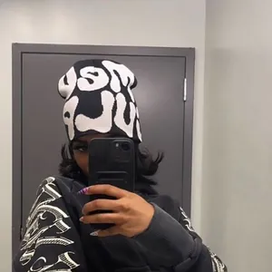 Close-up of the black and white knitted beanie featuring bold streetwear jacquard patterns