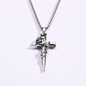 Macro detail of retro silver rose and cross pendant with intricate gothic carvings