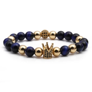Close-up of beaded bracelet with tiger eye stones, gold crown charm and micro-pave crystal ball