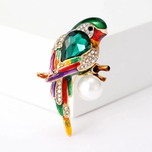 Detail of parrot brooch with multi-color enamel, green crystal, and pearl pendant