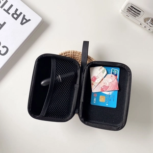 Internal view of a black zipper storage bag holding lipstick, cards, and folded cash