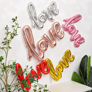 Makroaufnahme großer Love-Folienballons in Silber, Roségold, Pink, Rot und Gold für Deko