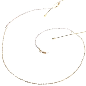 Detailed macro view of golden metal eyeglass chain with white pearl accents and silicone loops