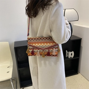Detail of bohemian woven bag with colorful long fringe and geometric jacquard strap