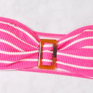 Detail of pink and white striped seersucker bikini top with amber tortoiseshell buckle