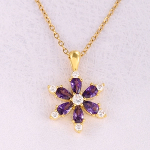 Elegant gold necklace featuring a purple zircon flower pendant with a sparkling crystal center