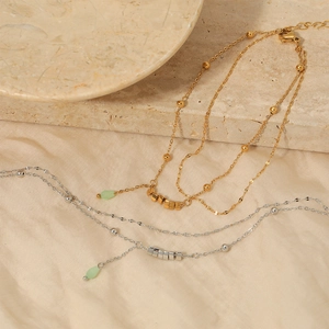 Double-layer stainless steel anklet with green bead and bar pendant in gold and silver