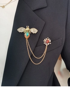 Close-up of vintage bee and flower brooch set with crystals on a black suit lapel