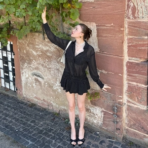 Abito in chiffon a pois neri con balze sovrapposte e colletto a polo in un set all'aperto