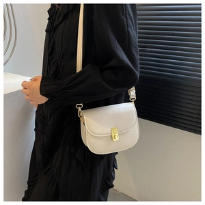 Side view of white textured saddle bag with gold metal buckle on female model