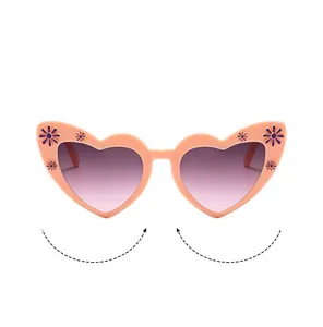 Detail of pink heart sunglasses with purple daisy accents and gradient lenses