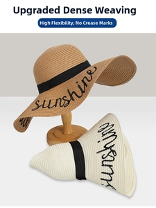 Detailed view of foldable straw sun hats with black sunshine embroidery and ribbon bow