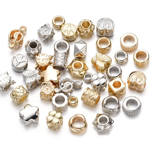 Detailed macro shot of gold and silver CCB beads in star, heart and clover shapes