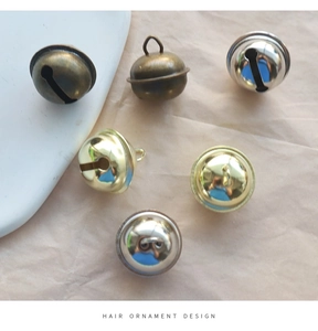 Gros plan de cloches métalliques de 22mm en bronze, or et argent pour l'artisanat