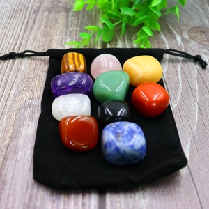 Close-up of colorful polished natural crystal stones in a black velvet pouch