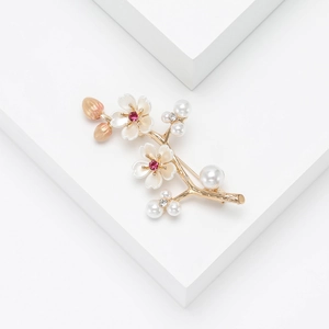 Elegant plum blossom branch brooch with gold base, white pearl flowers and red gemstones