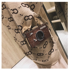 Close-up of brown glitter camera-shaped bag with Steal The Spotlight text and chain