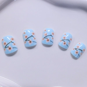 Short square blue press-on nails with pink cherry blossoms and gold glitter accents