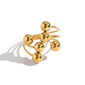 Detailed view of modern gold spiral ring with polished geometric spheres and mirror finish