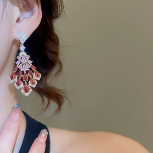 Detail of luxury pink rhinestone fringe earrings with silver needle on female model