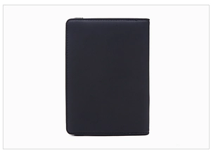 Macro detail of slim black RFID passport holder showing matte leather texture and neat stitching