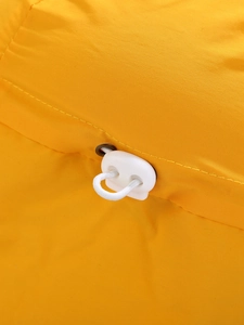 Macro detail of the yellow fabric sun hat featuring a white adjustable toggle and drawstring