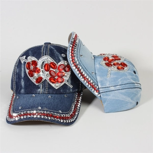 Close-up of blue denim baseball caps with sparkling rhinestone double heart patterns