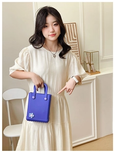 Nahaufnahme einer lila EVA-Gel-Mini-Tasche mit blauem Blumenanhänger-Dekoration