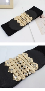 Detail of wide elastic waist belt with a golden heart-shaped rhinestone buckle closure