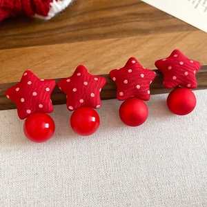 Detail of fabric-wrapped red polka dot star earrings with glossy red bead accents