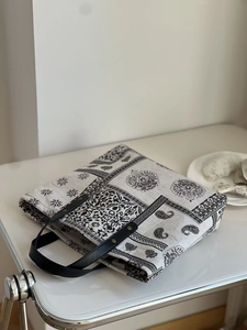 Detailed top view of paisley and geometric pattern tote bag with leather straps and rivets