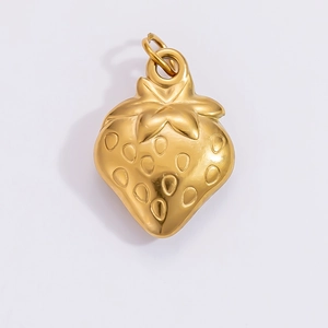 Macro shot of a strawberry shaped gold pendant with a polished metallic finish and ring