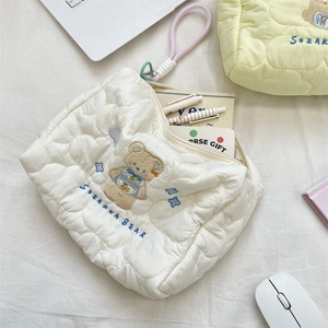 Detailed macro view of heart quilted pattern and cartoon bear embroidery on fabric bag
