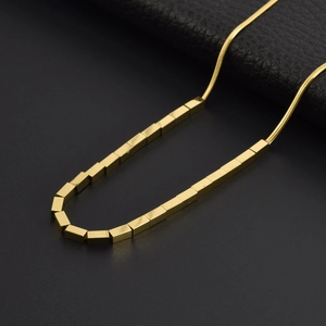 Gold minimalist snake chain necklace with small square beads on a black background