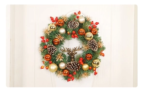 Detailed view of a Christmas wreath with gold baubles, pine cones and a bronze deer head