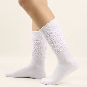 Detailed view of white knitted slouch socks featuring thick textured wavy ribbing