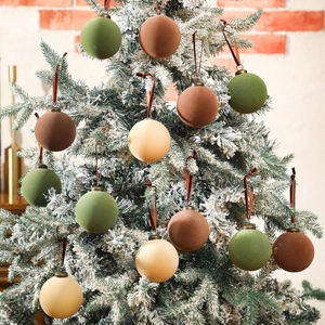Set of 15 velvet Christmas balls in olive green and brown on a snowy tree