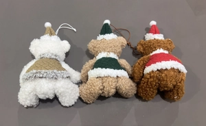 Detailed view of three plush Christmas bears with knitted hats and colorful vests