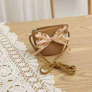 Détail du sac bandoulière en paille pour enfant avec grand nœud satiné et doublure fleurie