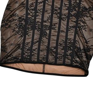 Detailaufnahme von schwarzer Spitze mit beigem Futter und vertikalen Netzstreifen am Kleid