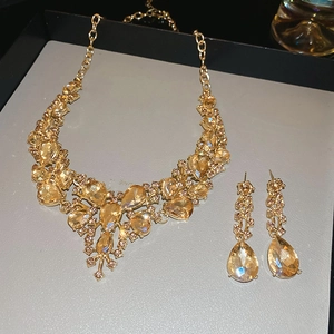 Close-up of luxury gold-plated necklace set with sparkling amber teardrop crystals