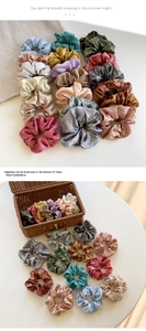 Detail of metallic silk scrunchies in various colors displayed in a woven basket